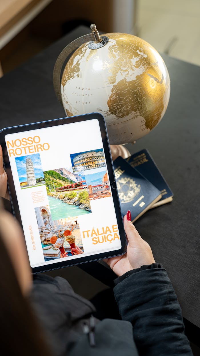 Traveler planning a trip to Italy and Switzerland using a globe, tablet, and passports.